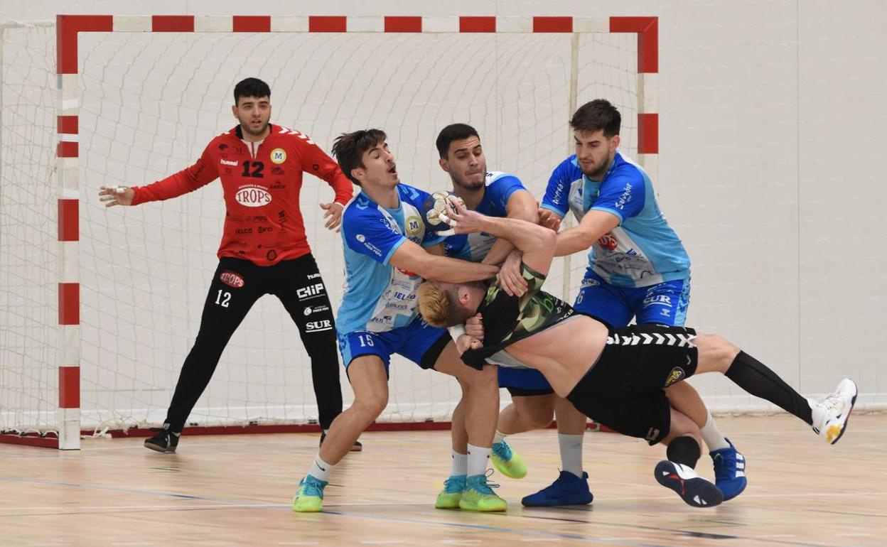 La defensa del Trops frena con contundencia a un contrario en el partido ante el Torrelavega. 