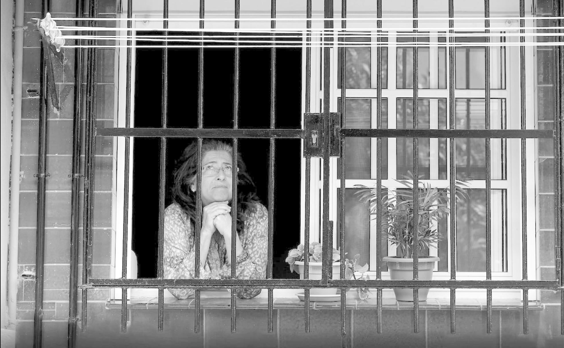 Una mujer mira al exterior desde la ventana de su vivienda en el barrio de Portada Alta , en pleno confinamiento severo de hace un año. 