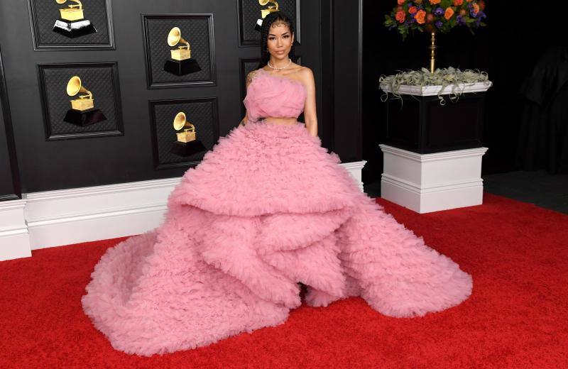 Jhené Aiko, en la alfombra roja de los Premios Grammy 2021, con un conjunto rosa de Monsoori. Demasiado algodón de azúcar.