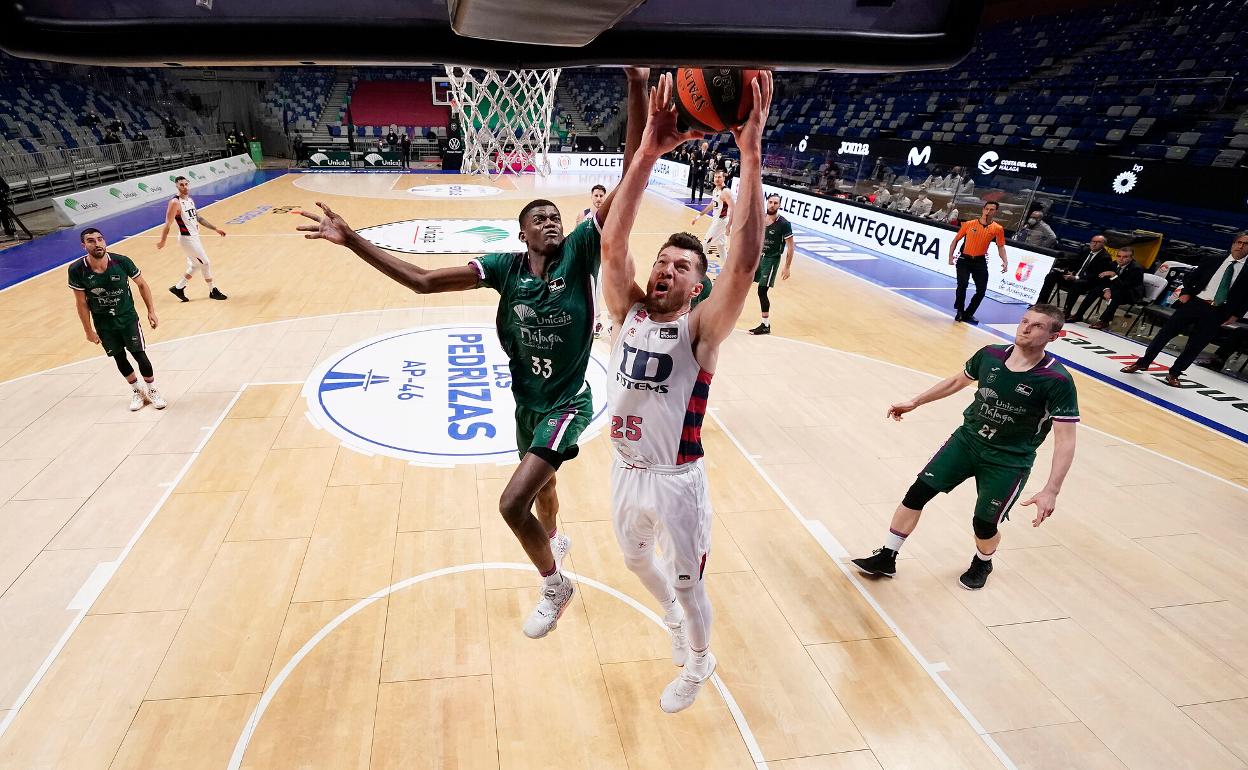 Nzosa se dispone a taponar al estadounidense Peters, del Baskonia. 