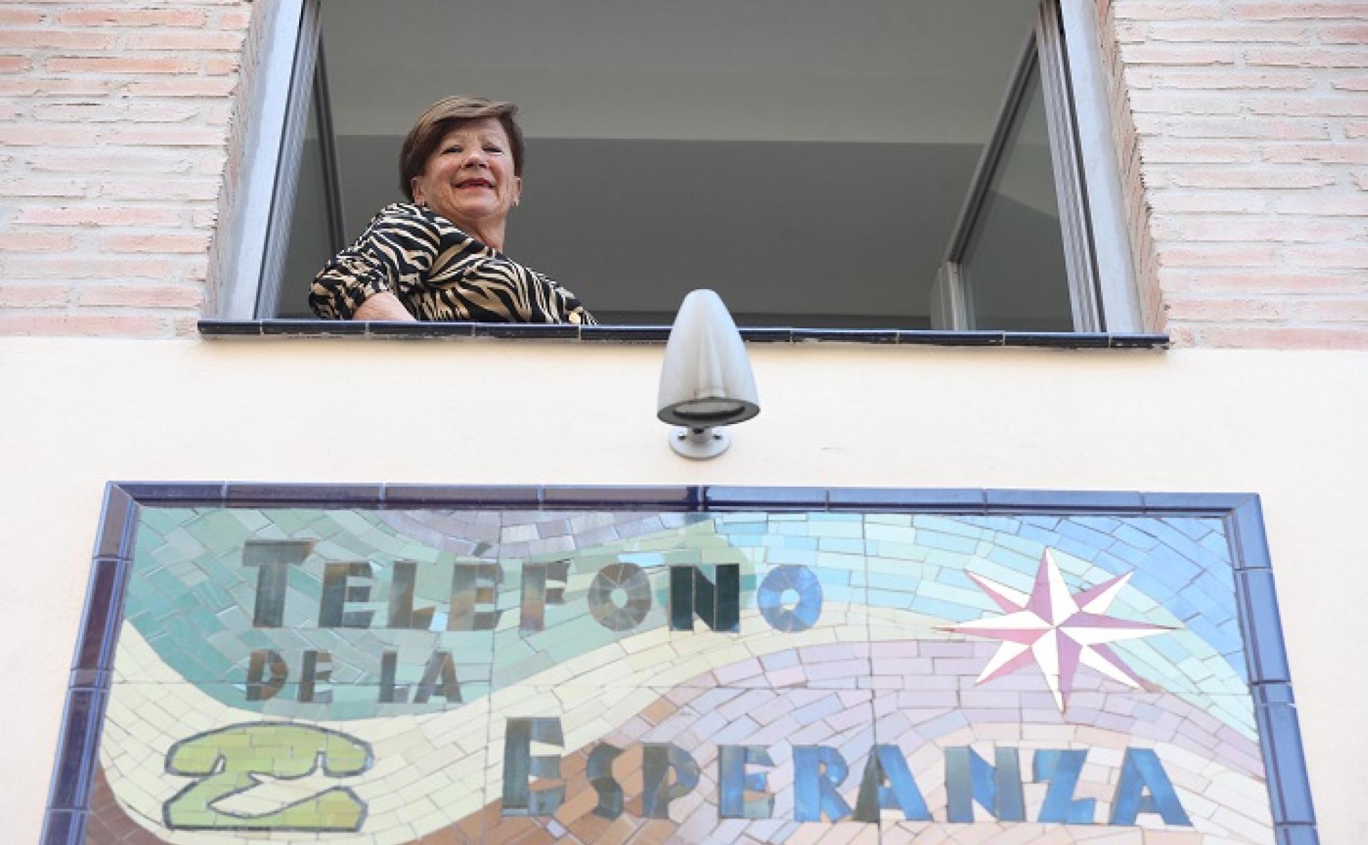 Carmen Orellana se asoma por la ventana de la sede del Teléfono de la Esperanza, donde lleva 40 años de voluntaria. 