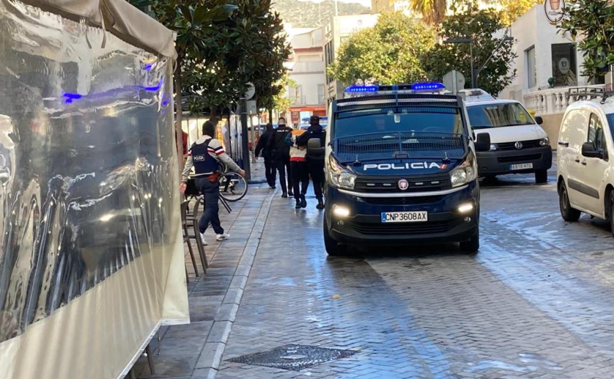 Los agentes, al conducir al furgón policial al segundo detenido. 