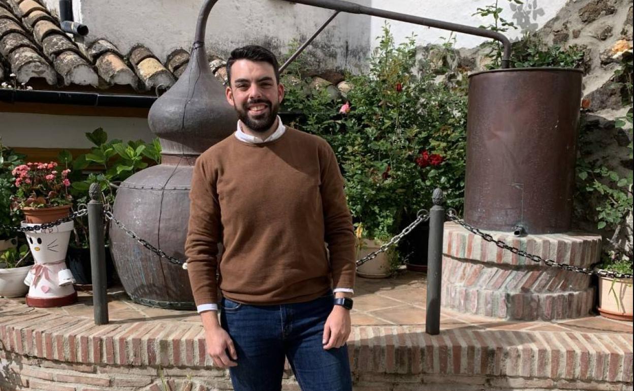 Benítez, en su pueblo, junto a esculturas que homenajean a la tradición de elaborar aguardiente. 