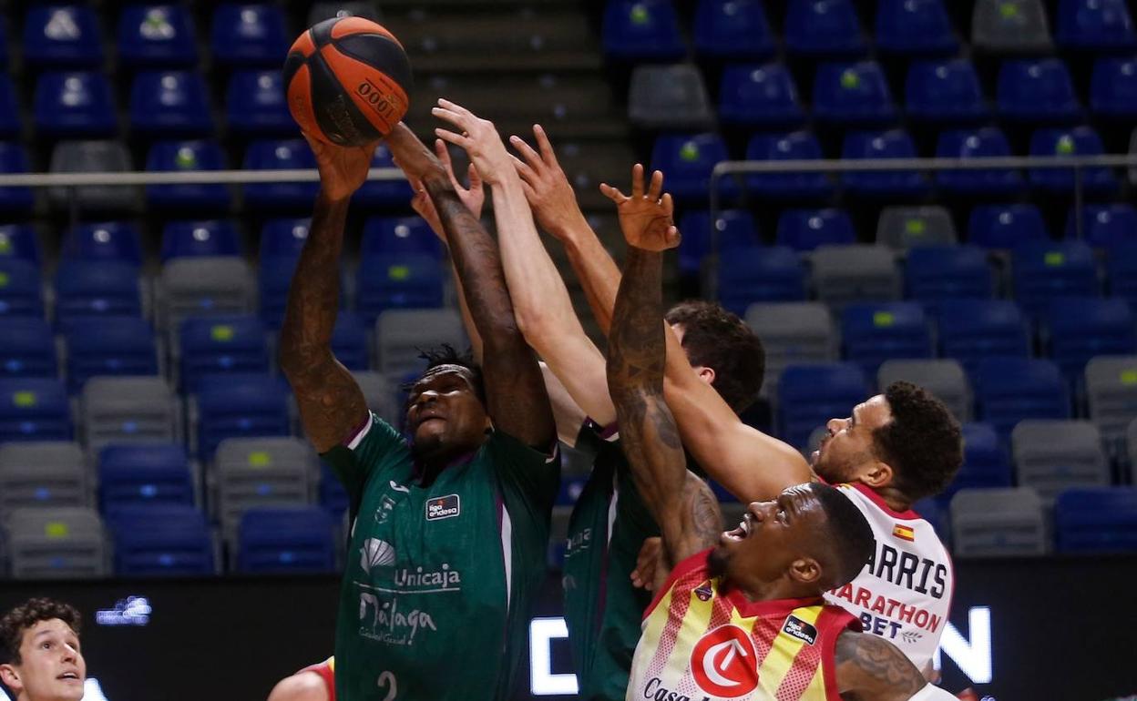 Deon Thompson trata de abrirse paso entre un mar de brazos, entre ellos los de Ennis y Harirs, del Casademont Zaragoza. 