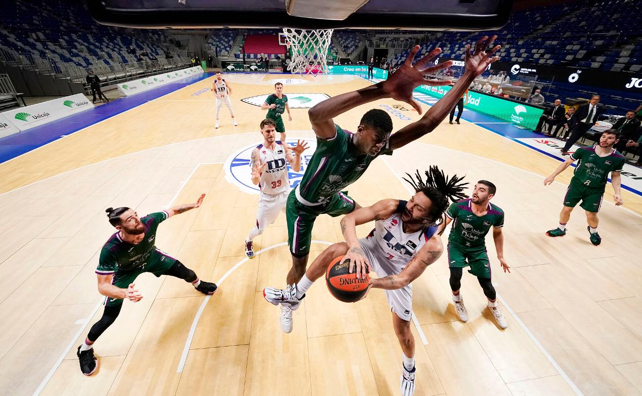 Yannick Nzosa intenta taponar a Henry en el partido entre el Unicaja y el Baskonia. 