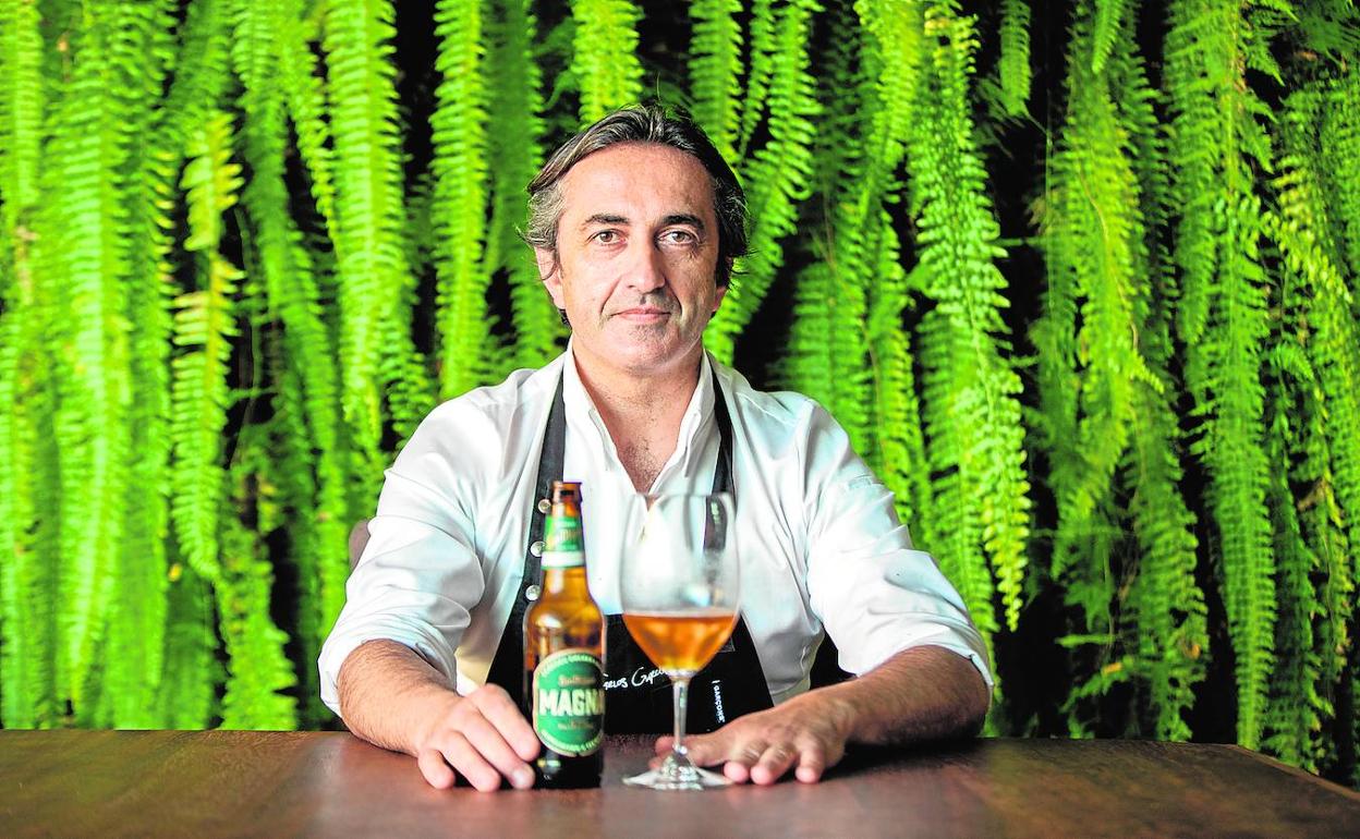 José Carlos García, con una Magna, ante el jardín vertical de su restaurante 