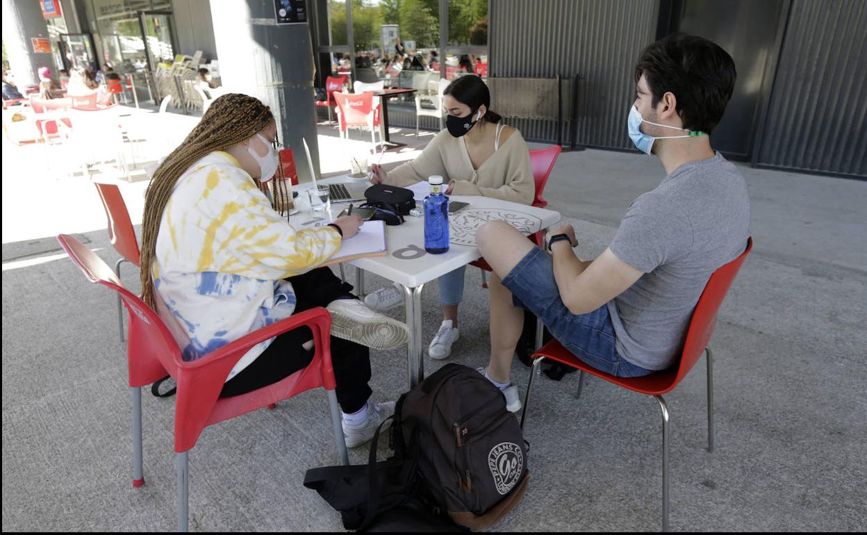 Jóvenes estudiantes en la cafetería de una universidad.