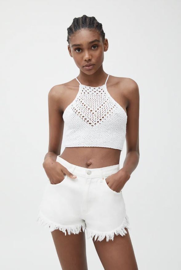 Este verano toca enseñar barriga. Las camisetas pierden centímetros de tela y dejan a la vista el ombligo. En la foto: top de croché en blanco de Pull&Bear.