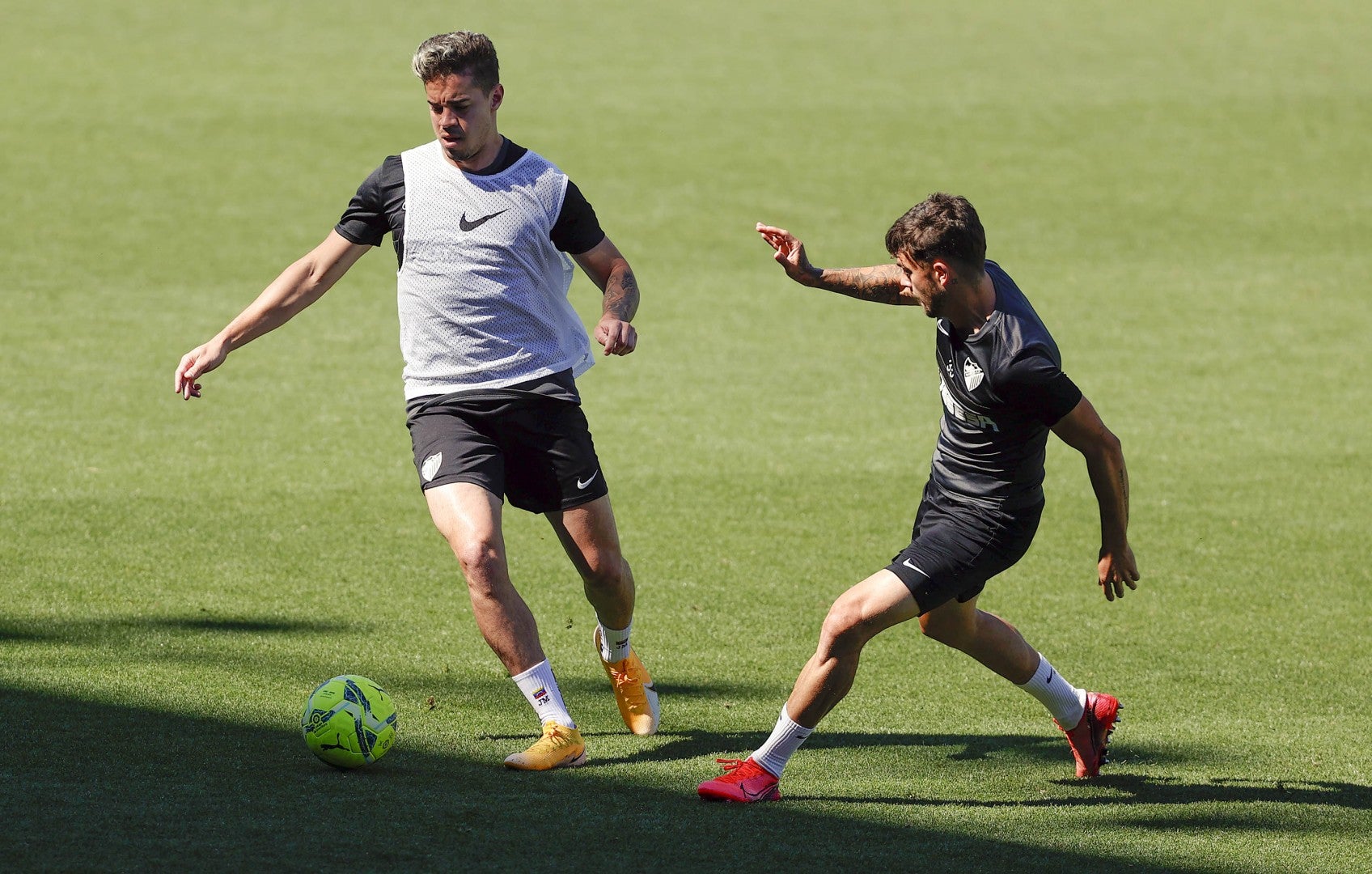 Los jugadores del Málaga, Josua Mejías (i) y Sergio Guerrero 'Mini', durante el entrenamiento de este sábado en La Rosaleda.