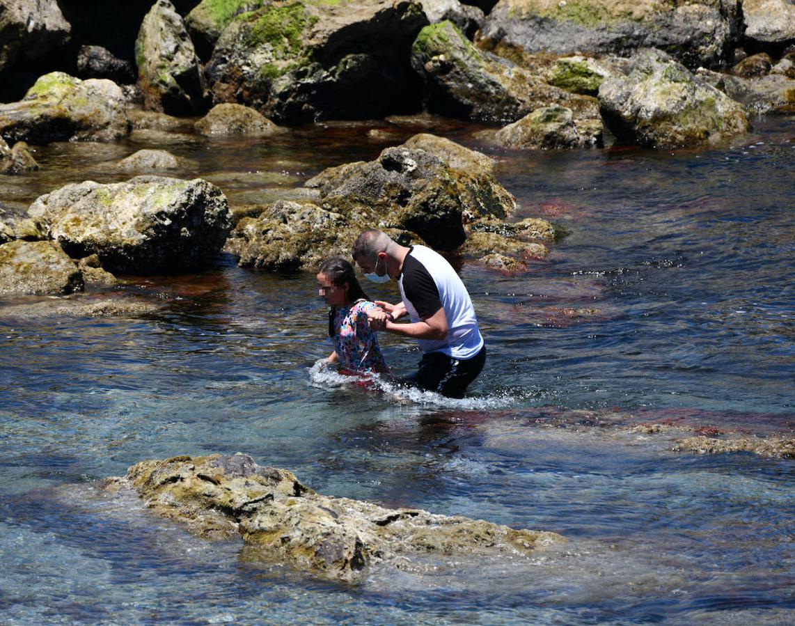 Una joven recibe ayuda para alcanzar la playa de la ciudad autónoma. 