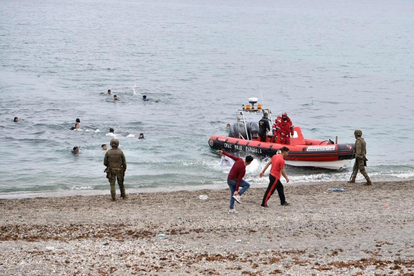 Los miembros de la Cruz Roja asisten a los migrantes que nadan hacia la costa del enclave español de Ceuta.