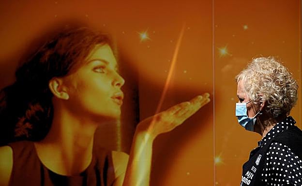 Una mujer con mascarilla en el centro de Gijón 