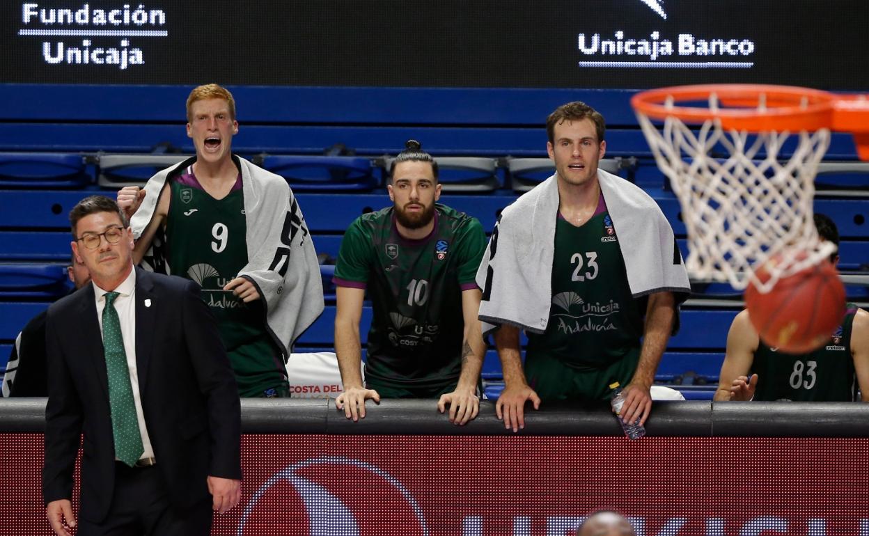 Los jugadores del Unicaja observan un partido de la Eurocup desde el banquillo. 