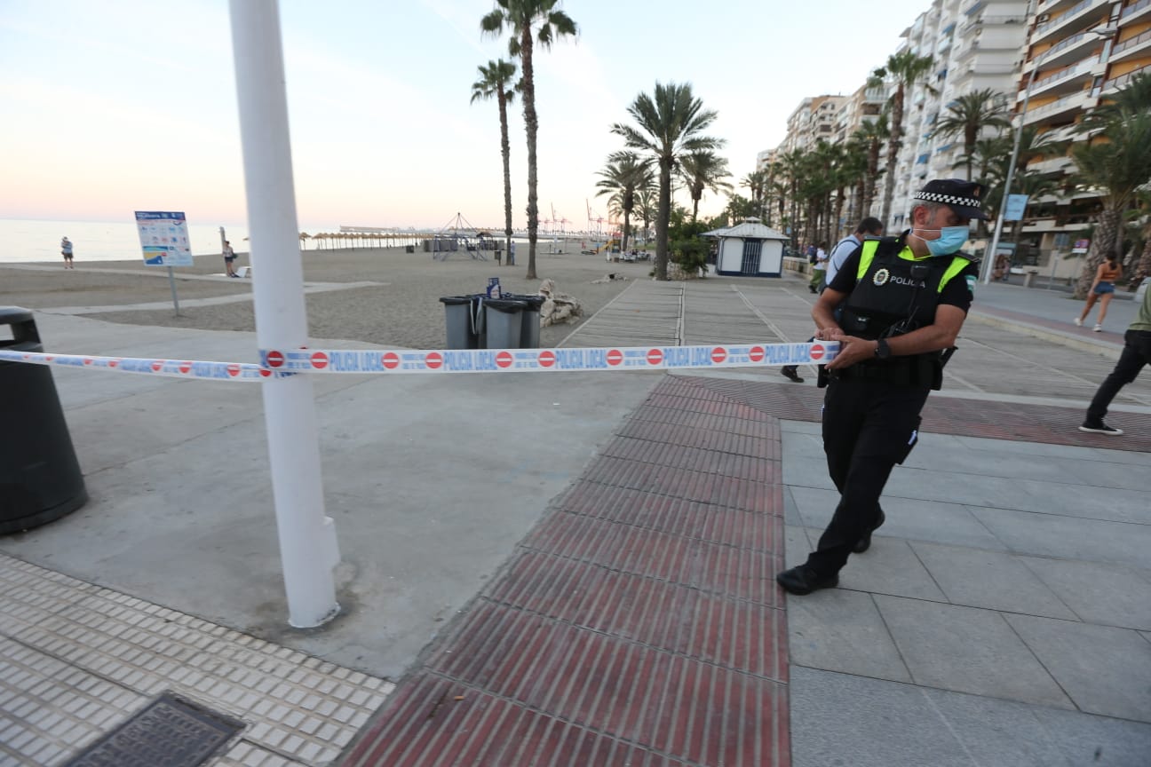 La Policía pone cintas para impedir el acceso a la arena e informa sobre la prohibición de entrar durante toda la noche