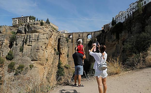 Una familia fotografía el puente de Ronda, en el interior de la provincia de Málaga.