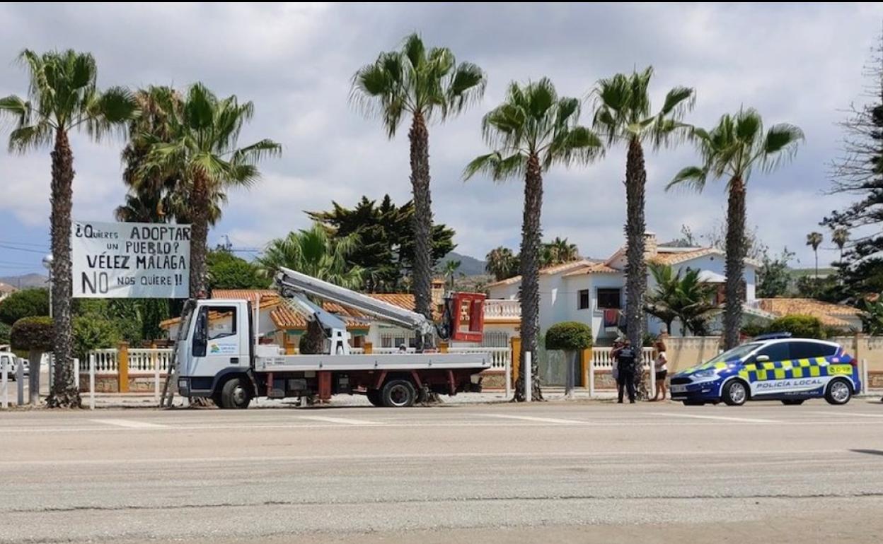 La Policía Local y un vehículo de la Mancomunidad Oriental, ayer junto a la pancarta, instantes antes de ser retirada. 