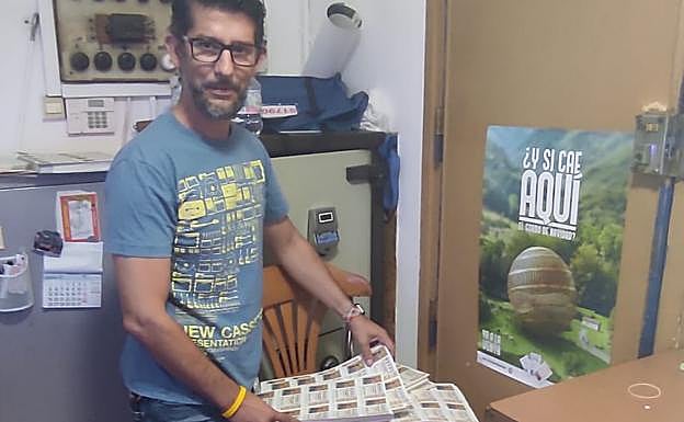 Un administrador muestra los primeros décimos. 