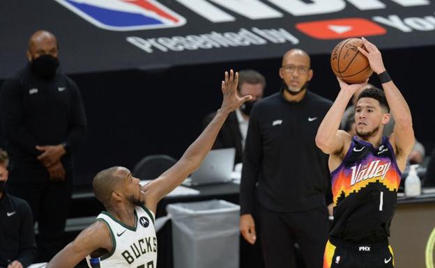 Devin Booker, que terminó con 31 puntos, lanza a canasta.