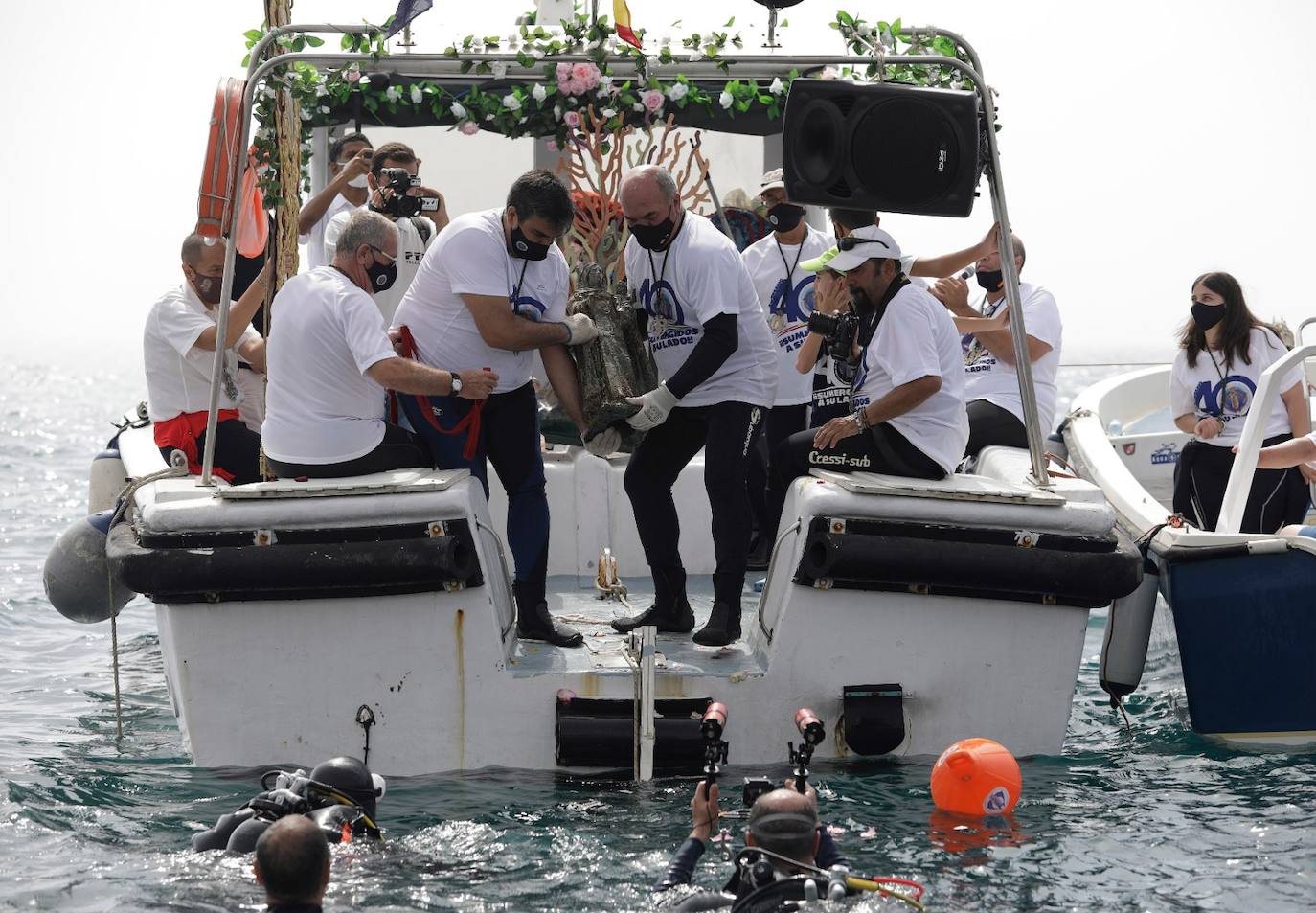 El estandarte ha sido llevado hasta el Puerto de la capital, donde en la casa de botes del Club Mediterráneo ha embarcado para dirigirse hacia las playas de La Malagueta.