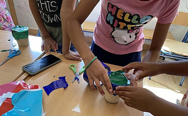 Este año, el tema de las colonias es la música, por lo que los niños crean maracas utilizando vasos reciclables y sal. 