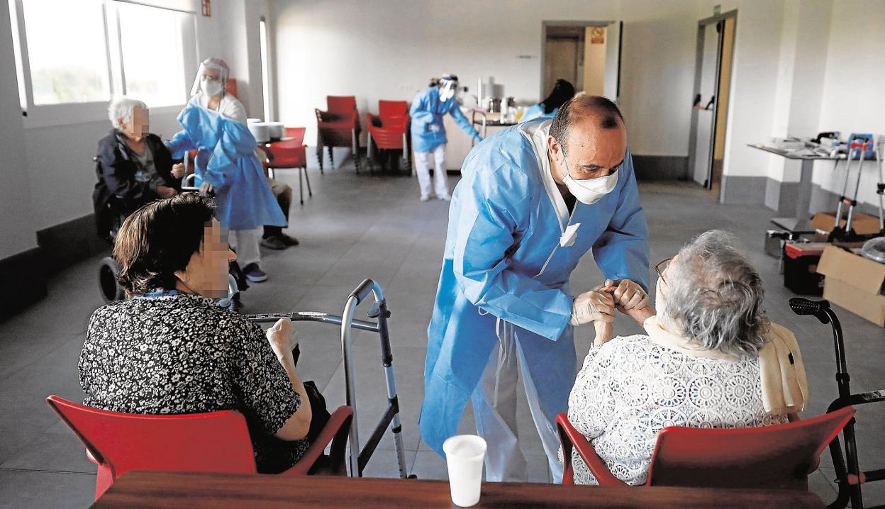 Un sanitario atiende a los ancianos alojados en la residencia. efe/archivo