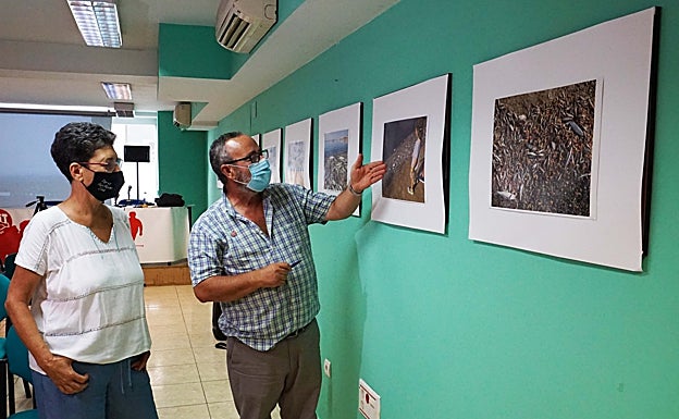 Vicente Sandoval, señalando una exposición de fotografías que muestran la actualidad del Mar Menor. 