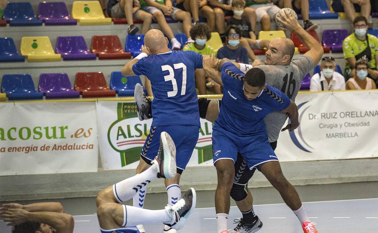 Baena, defendido por dos jugadores del Benidorm. 