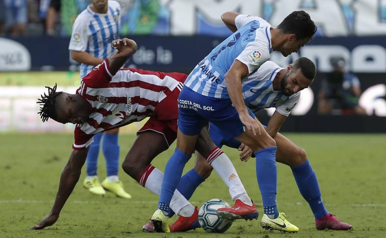 Sekou, en La Rosaleda entre Juan Carlos y Lombán en el Málaga-Almería de Liga en 2019 en que marcó el nuevo ariete blanquiazul. 