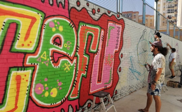 Eduardo da los últimos retoques a la palabra pintada en el muro. 