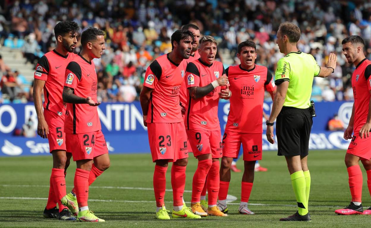 Los jugadores del Málaga protestan el penalti señalado tras una absurda acción de Juande. 