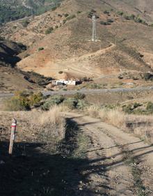 Imagen secundaria 2 - Los aerogeneradores forman parte del paisaje de esta ruta. Señales que indican el camino a seguir en el inicio. Descenso que hay que hacer al principio desde Carratraca.