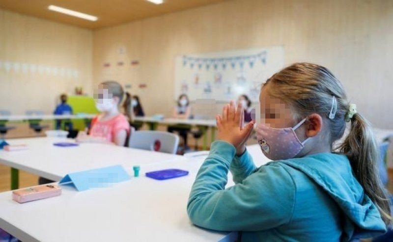 Menores asisten a clase con mascarilla en un centro escolar