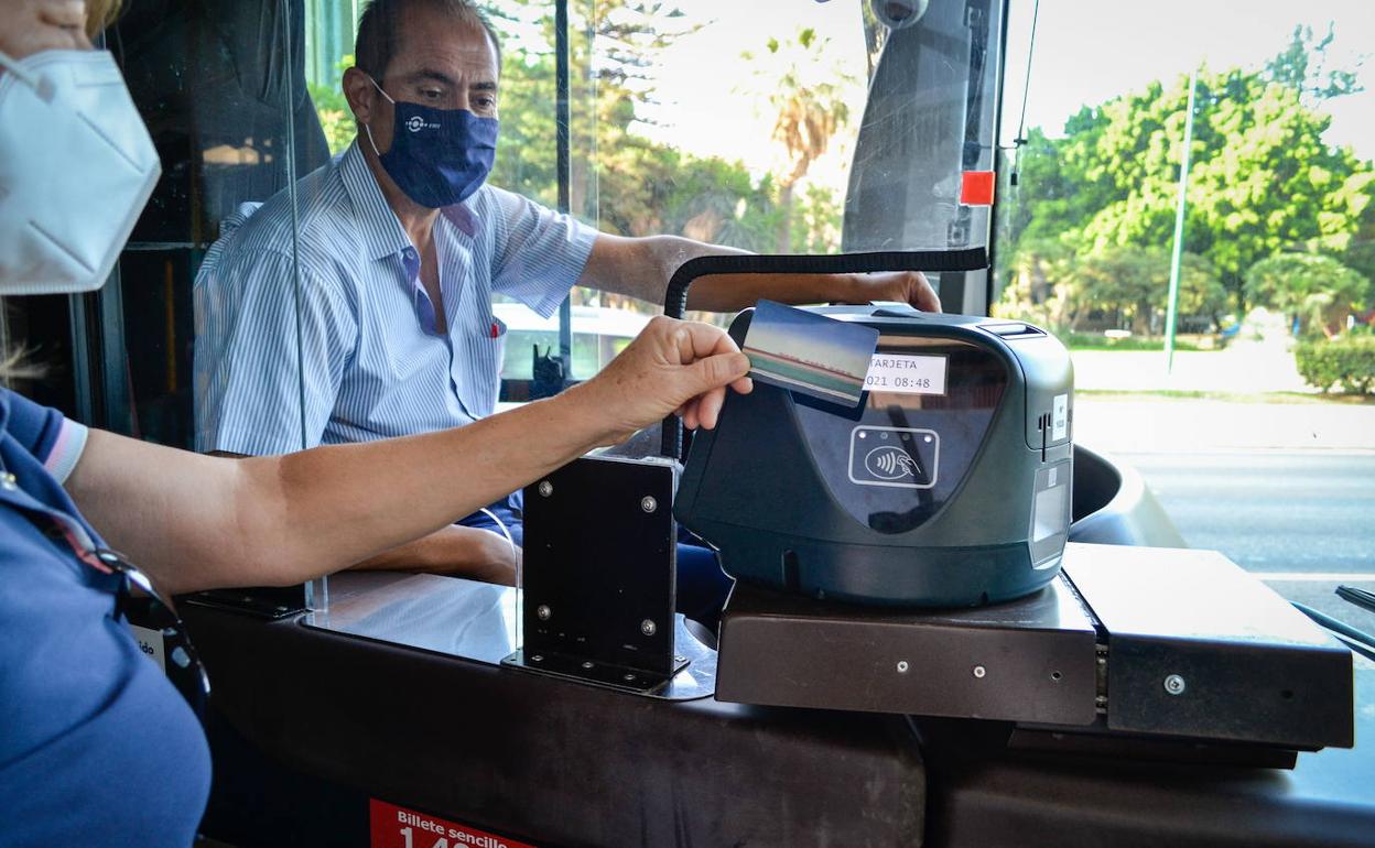 Una usuaria paga en el interior de un autobús de la EMT. 