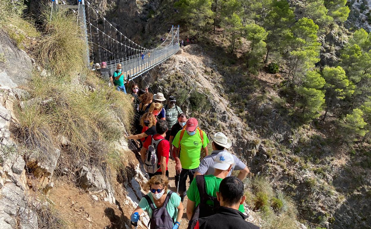 Excursionistas, en la pasarela entre Canillas de Aceituno y Sedella, en su apertura al público hace un año. 