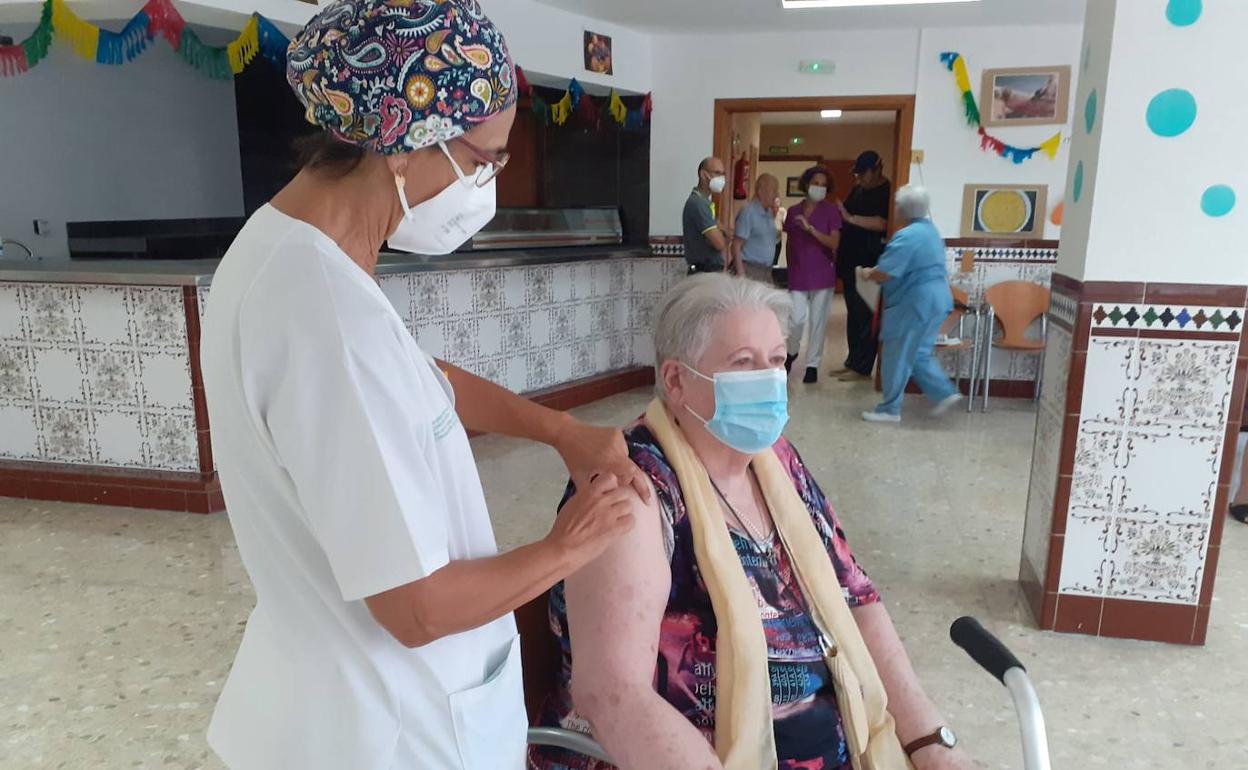 Imagen de archivo de una mujer a la que se le pone la tercera dosis contra el Covid. 