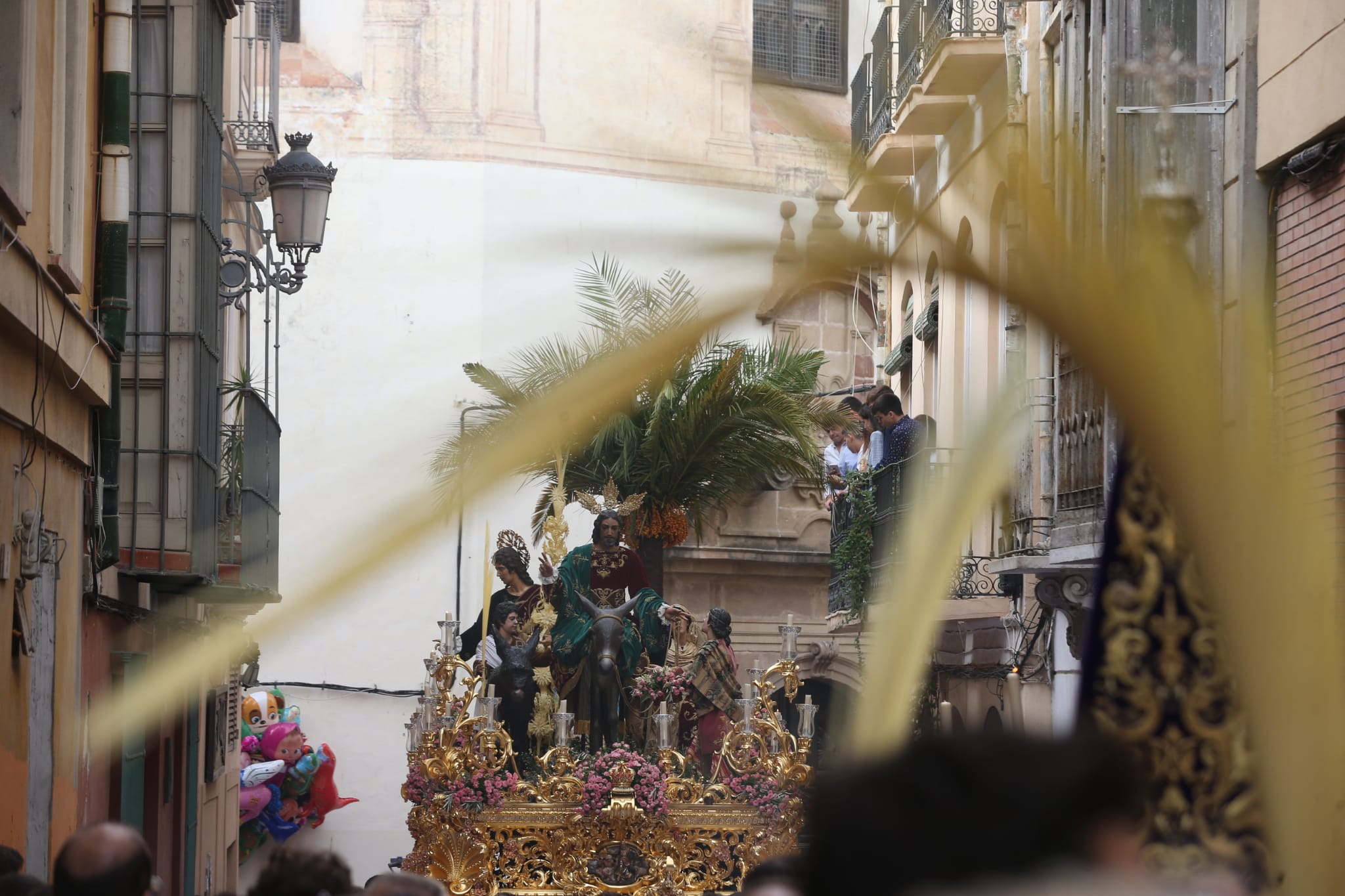 Dieciséis tronos recorren la ciudad para conmemorar el centenario de la Agrupación de Cofradías de Málaga en un evento histórico. En la imagen, Pollinica.