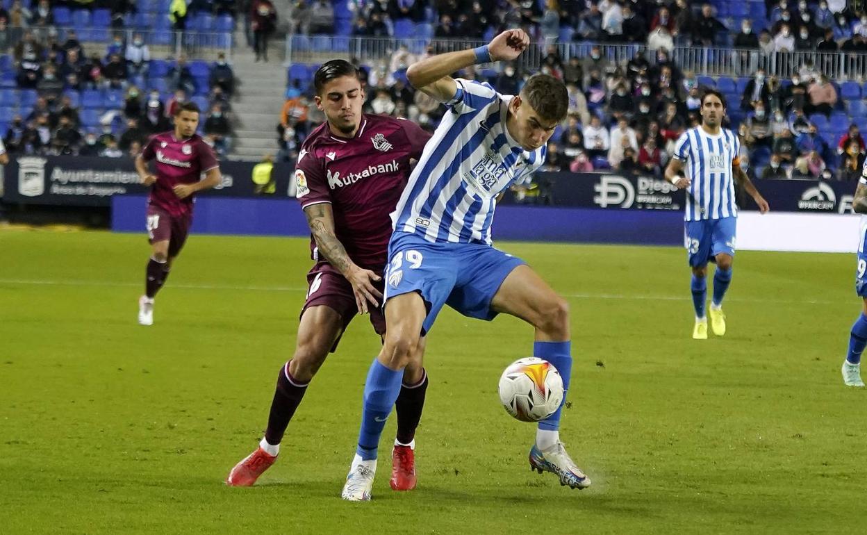 Roberto protege la pelota ante Cristo, lateral cedido por el Málaga a la Real. 