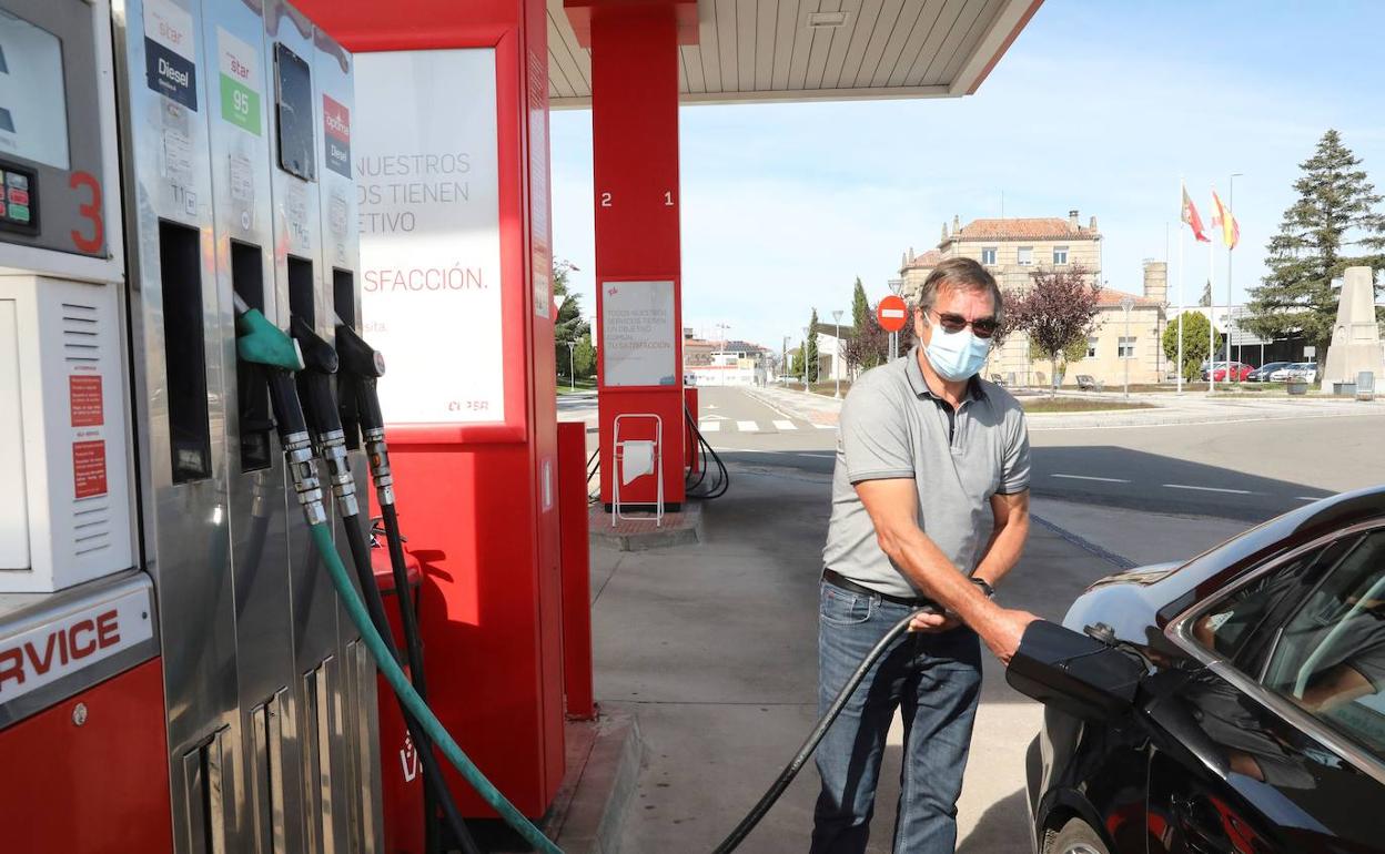 Un hombre reposta en una gasolinera. 