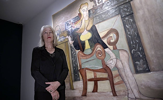 Marianne Vilató, la viuda del artista, junto a un cuadro en el que aparece ella retratada. 