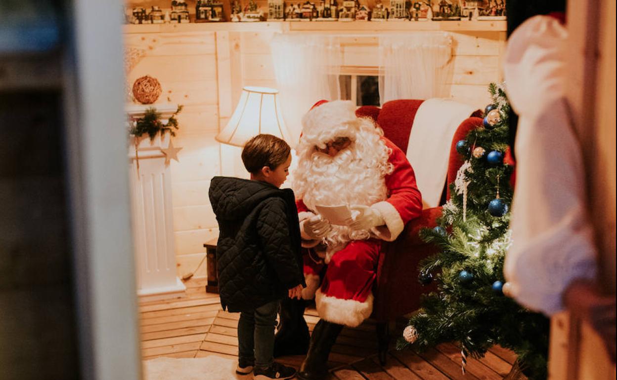 Un pequeño entregando su carta a Papá Noel en Puerto Banús. 