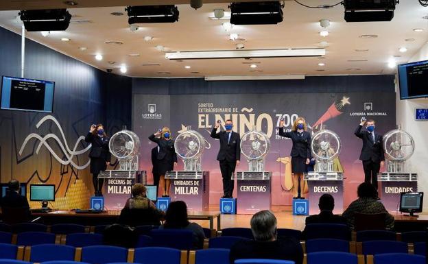 Operarios muestran el número del primer premio del sorteo extraordinario de lotería del Niño, el 41.665, vendido íntegramente en Logroño