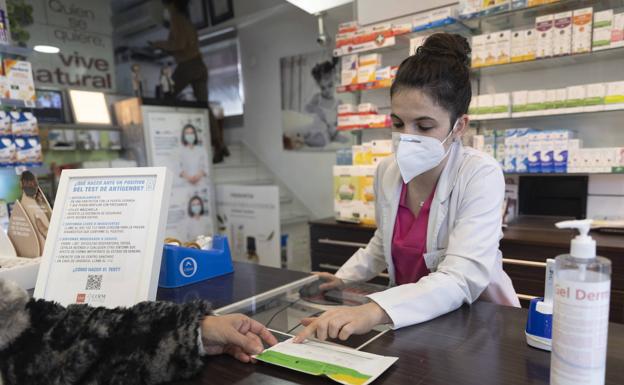 Una farmacéutica vende un test de antígenos.