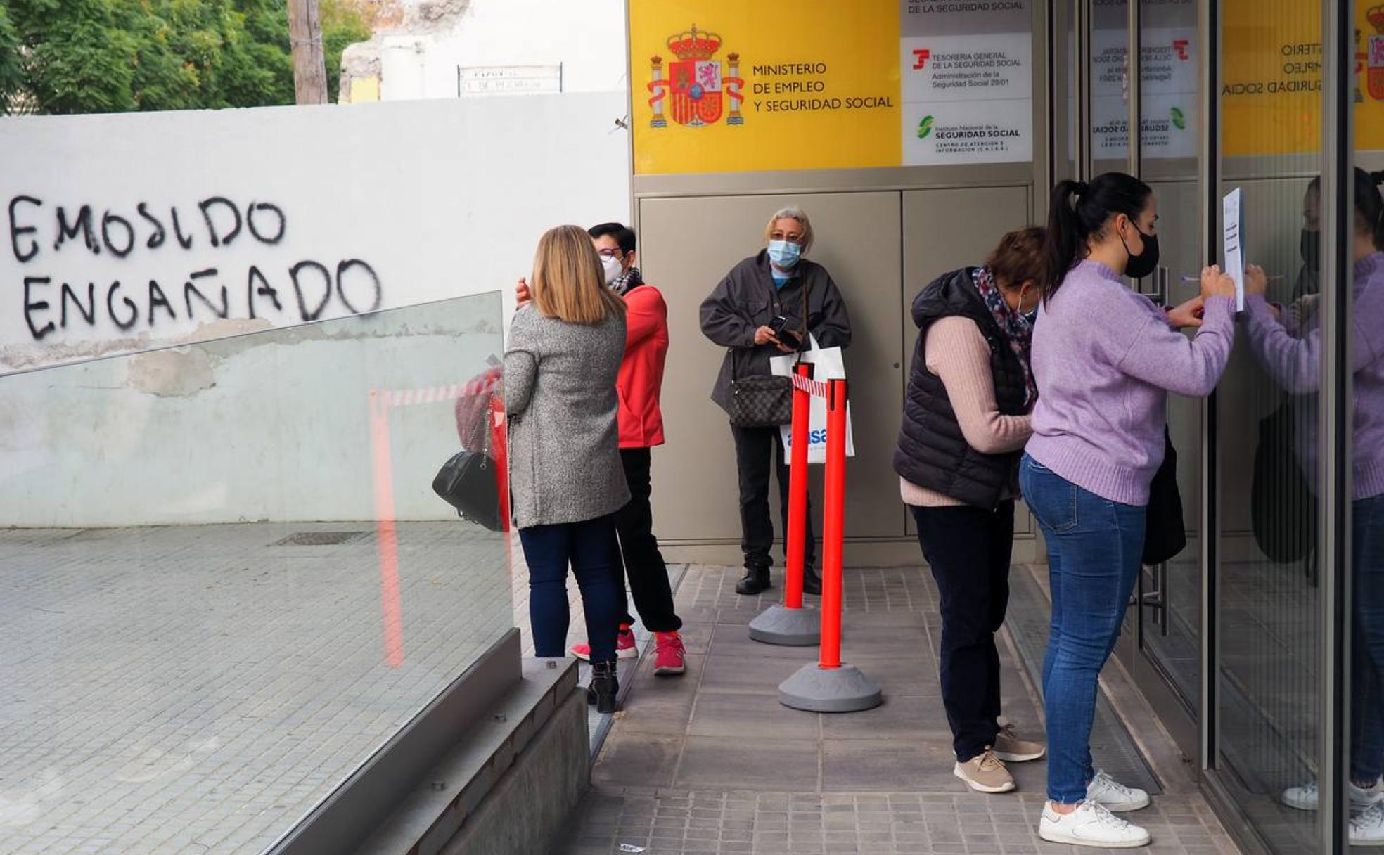 Un grupo de usuarios espera a las puertas de una oficina de la Seguridad Social en Málaga. 