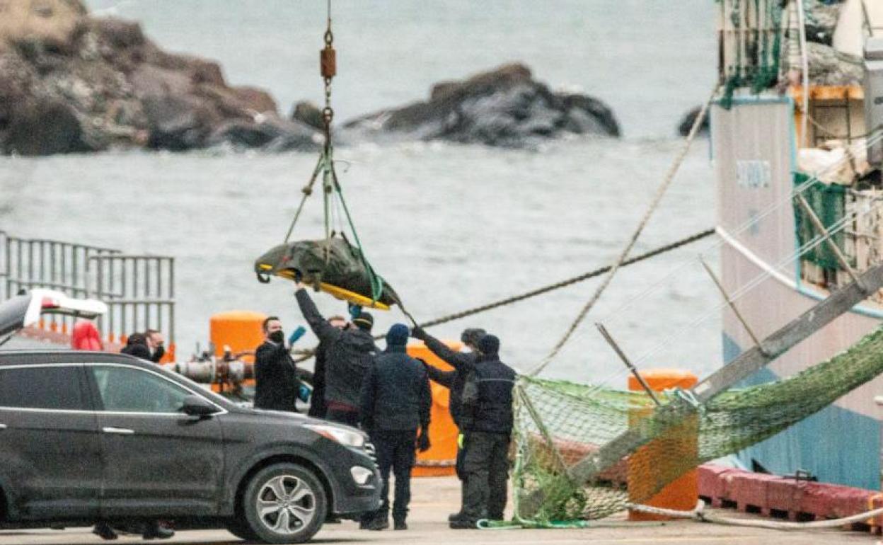 El primero de los barcos que portan a los tres supervivientes y los nueve cuerpos 