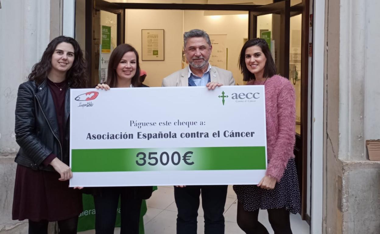 María Jesús, Carmen y Cristina, junto a un responsable de AECC, en la entrega del cheque.