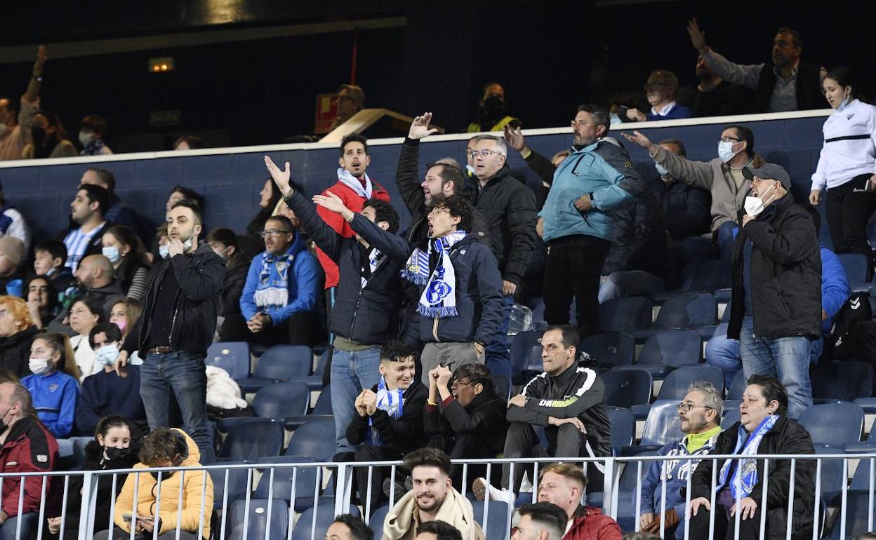 Aficionados del Málaga protestan de pie por una jugada del partido del sábado. 