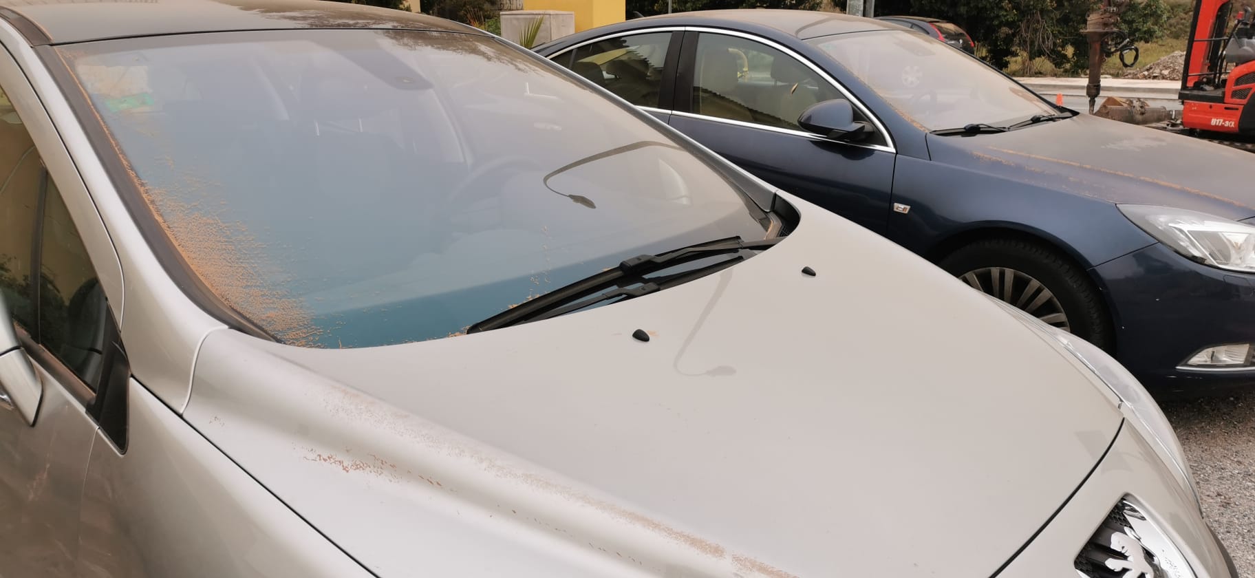 La intrusión de una gran masa en suspensión está dejando las calles y los coches cubiertos de polvo rojo, el mismo color que el cielo.