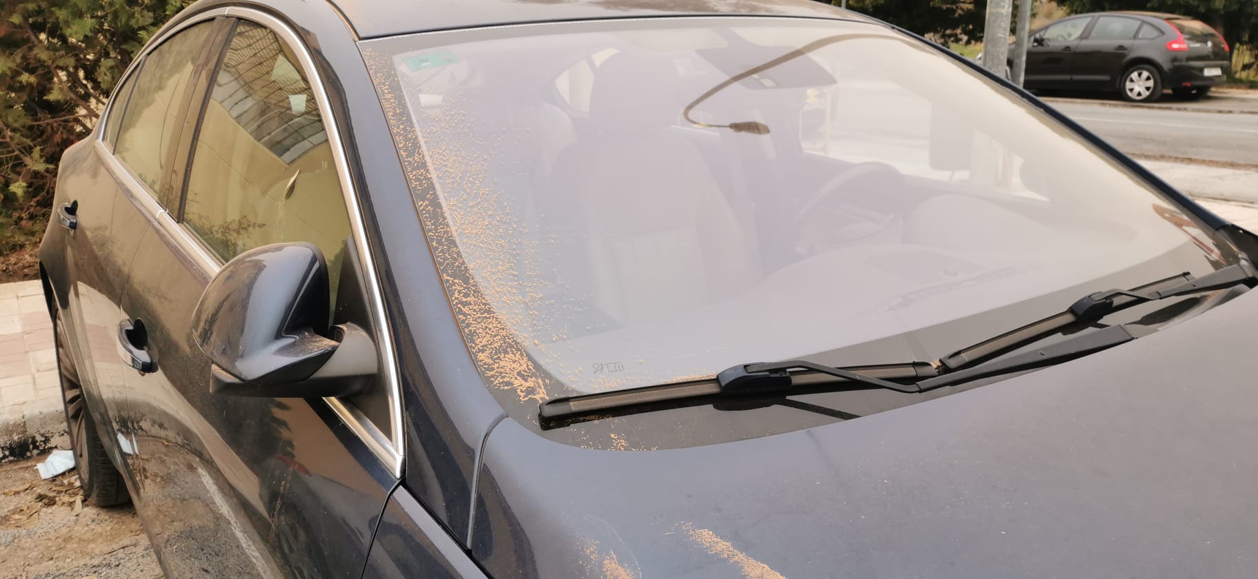 La intrusión de una gran masa en suspensión está dejando las calles y los coches cubiertos de polvo rojo, el mismo color que el cielo.