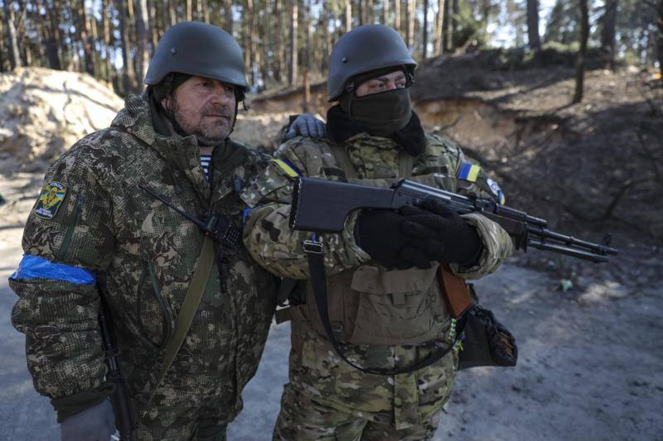 Dos miembros de las Fuerzas de Defensa Territorial con armas en un puesto de control de seguridad en Kiev.