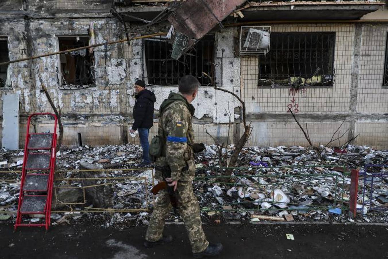 Un hombre limpiando los escombros de un edificio dañado por los bombardeos en Kiev.